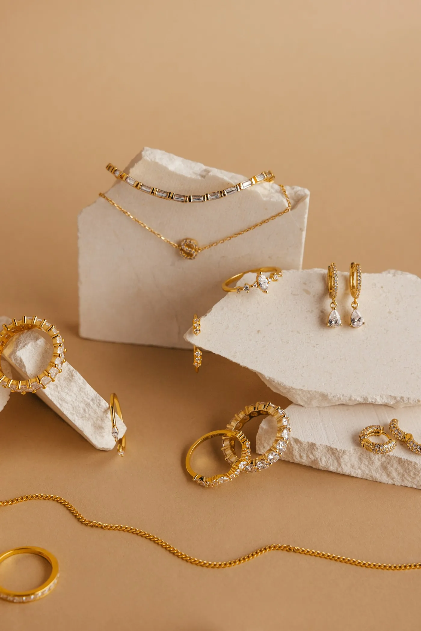 Gold jewellery on white stones